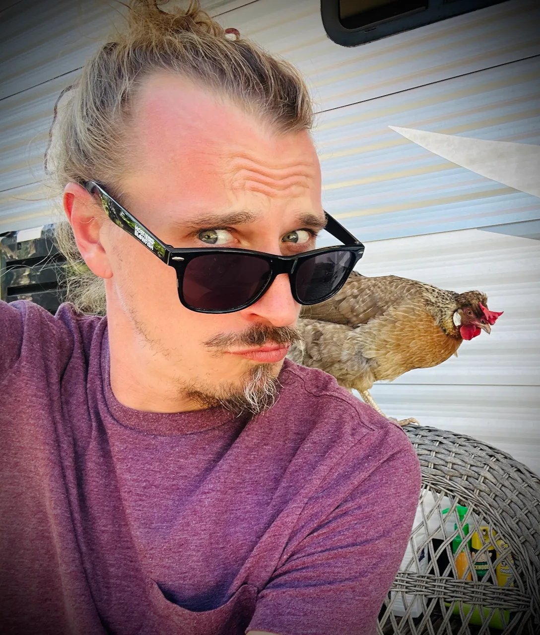Andy Brazil with a chicken perched beside him
